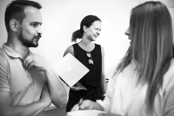 Three individuals talking together. Photo